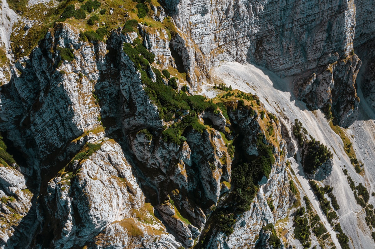 Bare limestone crags and scree slopes falling away below a grassy ridge