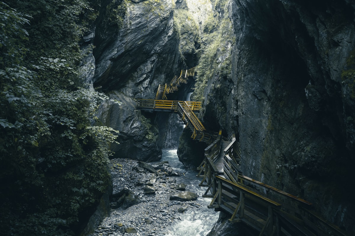 Wooden walkways and stairs zigzagging up a narrow rocky gorge above a stream