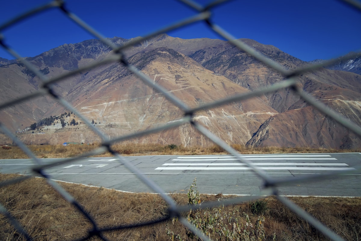 A view through a chain link fence of an airport runway